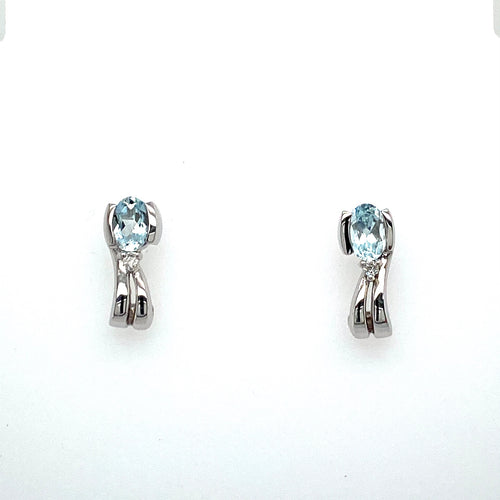 This Pretty Little Pair of 14 Karat White Gold Earrings Feature an Oval Aquamarine Gemstone Semi Bezeled into the Earring with a Little Diamond Accent at the Bottom of the Stone. The Earrings are Secured with Posts and Push on Backs.