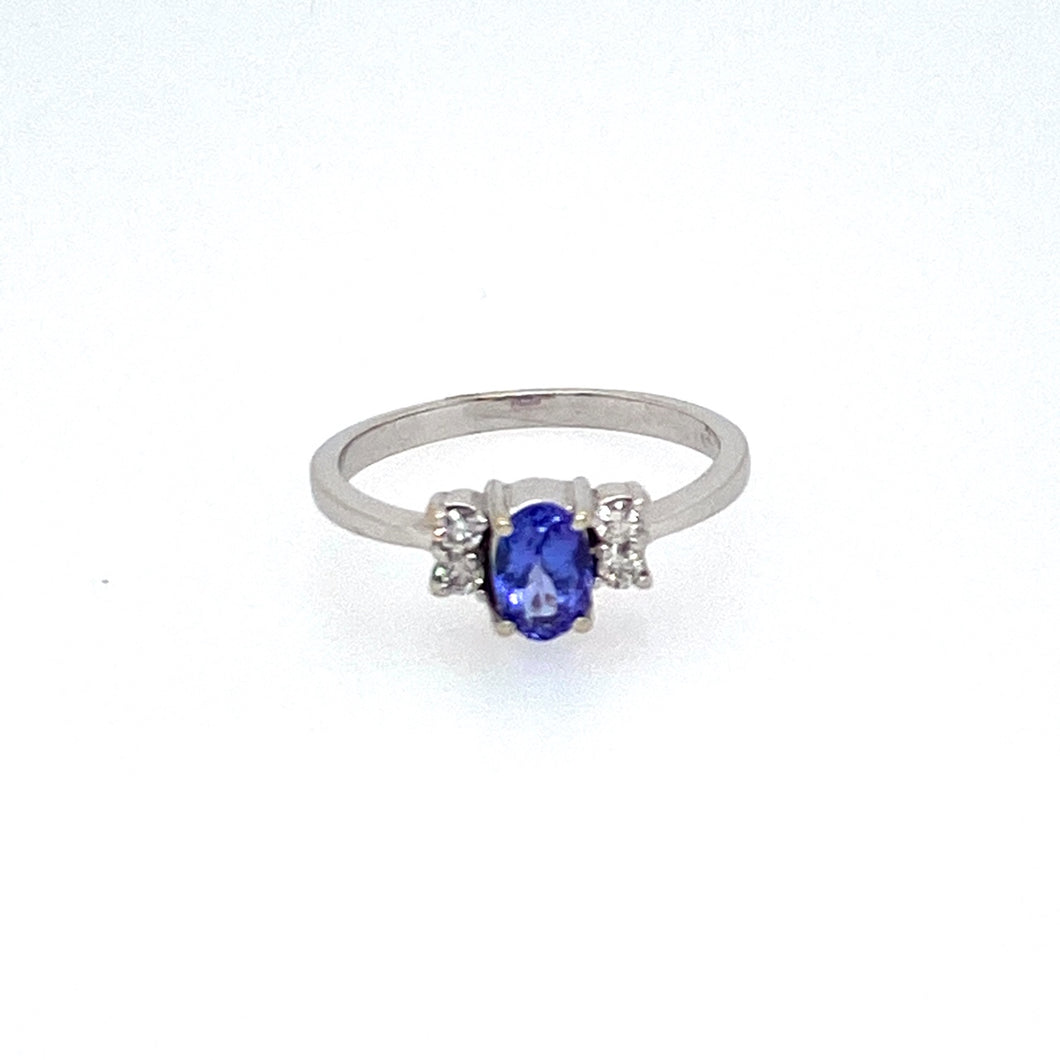 A Beautiful Bold Blue Oval Tanzanite Gemstone sets in the Center of this 14 Karat White Gold Estate Ring, with Two Diamonds set on Each Side of the Gemstone.  Total Weight 2.4 Grams  Finger Size 6.5