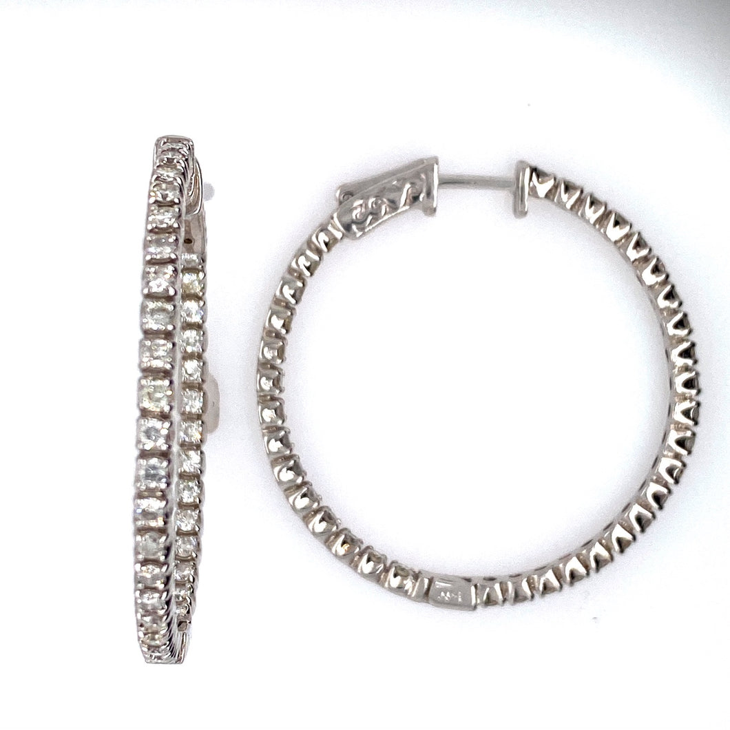 These 14 Karat White Gold Round Hoop Earrings Feature 1.40 Diamond Total Weight of Round Diamonds set Inside and Outside of the Earring. The Earrings Feature a Push Down Click in Closure.