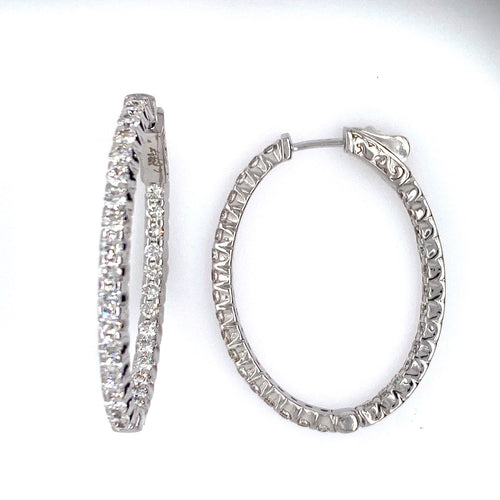 These 14 Karat White Gold Oval Hoop Earrings Feature 2.72 Carat Total Weight of White Sparkling Diamonds set inside and Outside of the Earring. The Hoops are Secured with a Push down click in Closure.