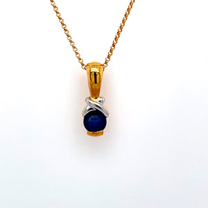This Beautiful 18 Karat Yellow Gold and White Gold Necklace Features a Beautiful Round Blue Sapphire Gemstone with a White Gold Accent above it, and a High polished Bail. The Chain is an 18 Karat Yellow Gold 16" Link Style.  Total Weight 4.8 Grams 