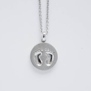 mommy chic baby's footprints round disc necklace in sterling silver.  can be worn at 18" or 20"