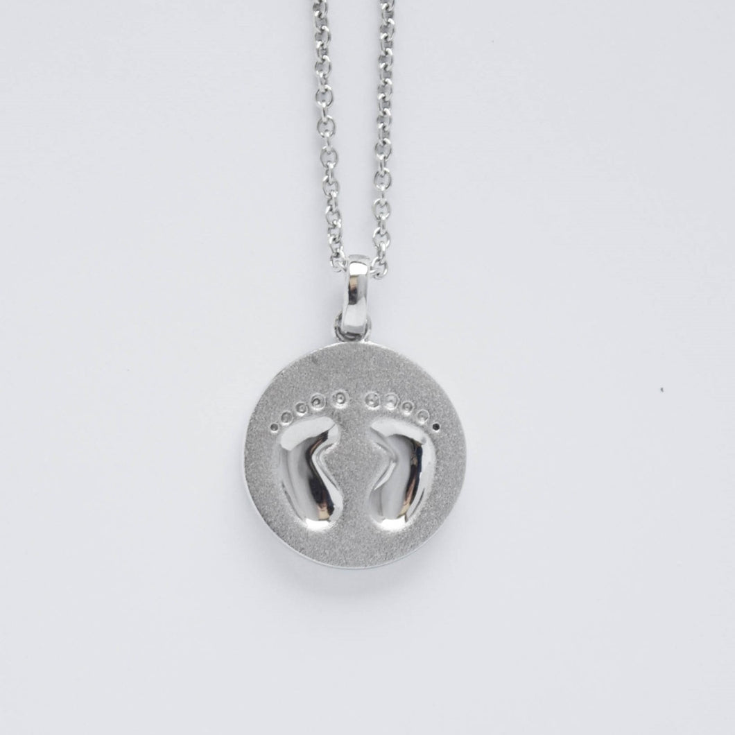 mommy chic baby's footprints round disc necklace in sterling silver.  can be worn at 18