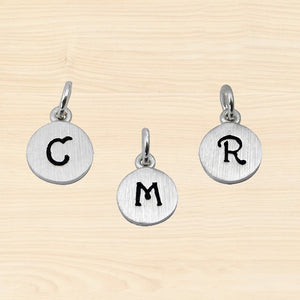 mommy chic "initial" charms in a round shaped disc. made in sterling silver 